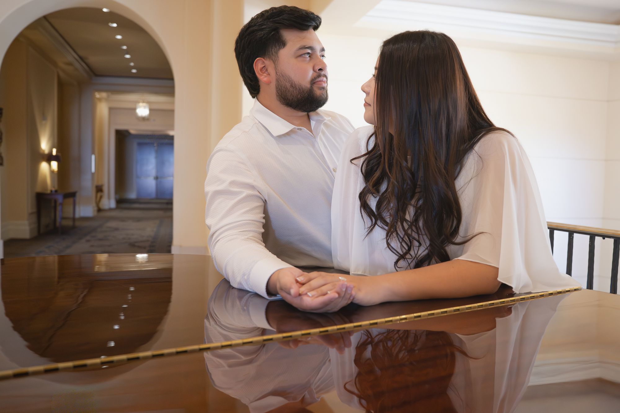 Nicky and Gabe holding hands at a grand piano